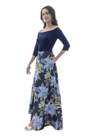Vestido largo azul marino con estampado floral, escote off shoulder, manga larga y falda línea A con tablones y abertura frontal, colección Massima otoño-invierno, vista de perfil