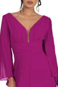 Close-up of a magenta pleated dress with a deep V-neckline and long sleeves; gold dangling earrings visible.