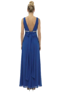 Back view of a woman in a blue evening gown with a deep V back and a waist bow, wearing a high bun and hoop earrings.