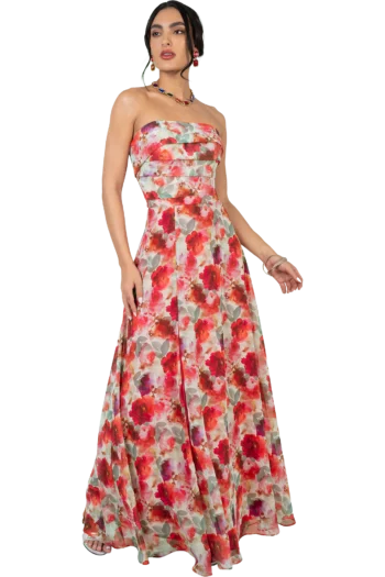 Model wearing a strapless, floor-length floral gown in red, pink, and green tones, accessorized with colorful jewelry and a bracelet.