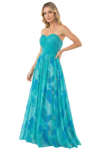 Woman in a turquoise strapless pleated evening gown with a waist sash, standing with one hand on her hip against a black background.