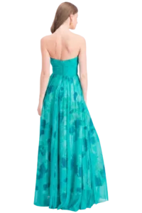 Back view of a woman in a turquoise strapless gown with a pleated, watercolor-style skirt.