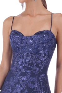 Close-up of a woman wearing a navy blue sequined spaghetti-strap dress.