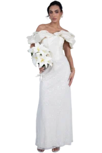 Bride in a white off-the-shoulder wedding gown with ruffled sleeves, holding a bouquet of white lilies.