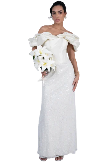 Bride in a white off-the-shoulder wedding gown with ruffled sleeves, holding a bouquet of white lilies.