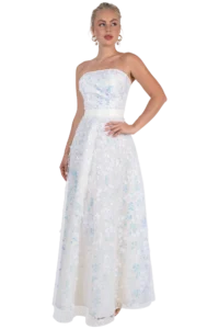 Woman wearing a strapless white ball gown with iridescent floral appliqués, posing with hand on hip.