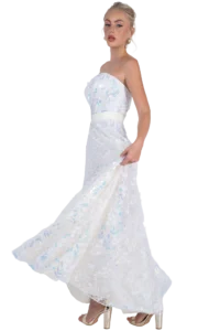 Woman in a strapless white gown with iridescent butterfly appliqués walking in nude-heeled sandals, shown in a side pose.