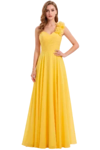 Fashion model in a bright yellow, floor-length gown with a ruched bodice and a large floral appliqué on the right shoulder, standing with one hand on her hip.