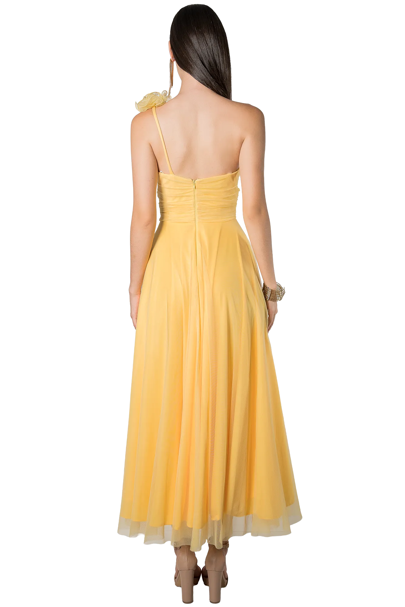 Back view of a woman in a pale yellow, one-shoulder evening gown with a ruched bodice and flowing skirt.