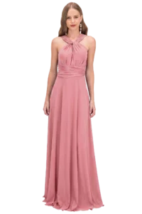 Woman in a dusty pink halter-neck evening gown standing against a black background.