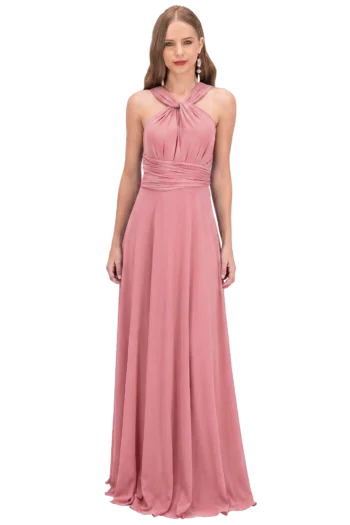Woman in a dusty pink halter-neck evening gown standing against a black background.