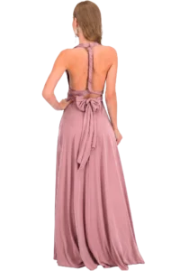 Back view of a woman in a dusty pink backless gown with a twisted halter strap and a bow at the waist.