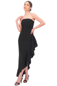 Woman in a strapless black evening gown with a layered asymmetrical hem, standing in high heels, posing with one hand at her waist.