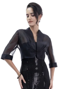 Woman in a sheer black jacket over a sequined black dress, facing left and looking down