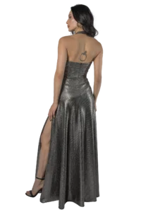 Back view of a woman wearing a metallic silver strapless gown with a high slit, hoop earrings, and black heels; a small tattoo is visible on her upper back.
