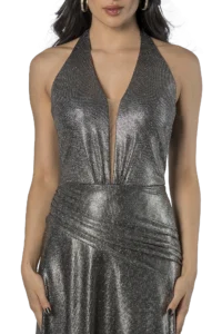 Woman in a glittery silver halter dress with a plunging neckline, hands at her sides.