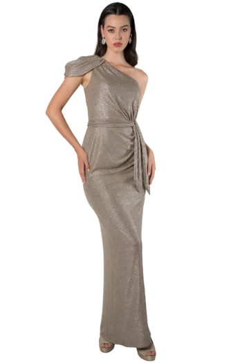 Woman in a sparkling gold one-shoulder evening gown with statement earrings, posing with hand on hip against a black background.