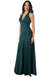 Woman in a sparkling teal halter-neck evening gown, standing with hands at her sides against a black background.