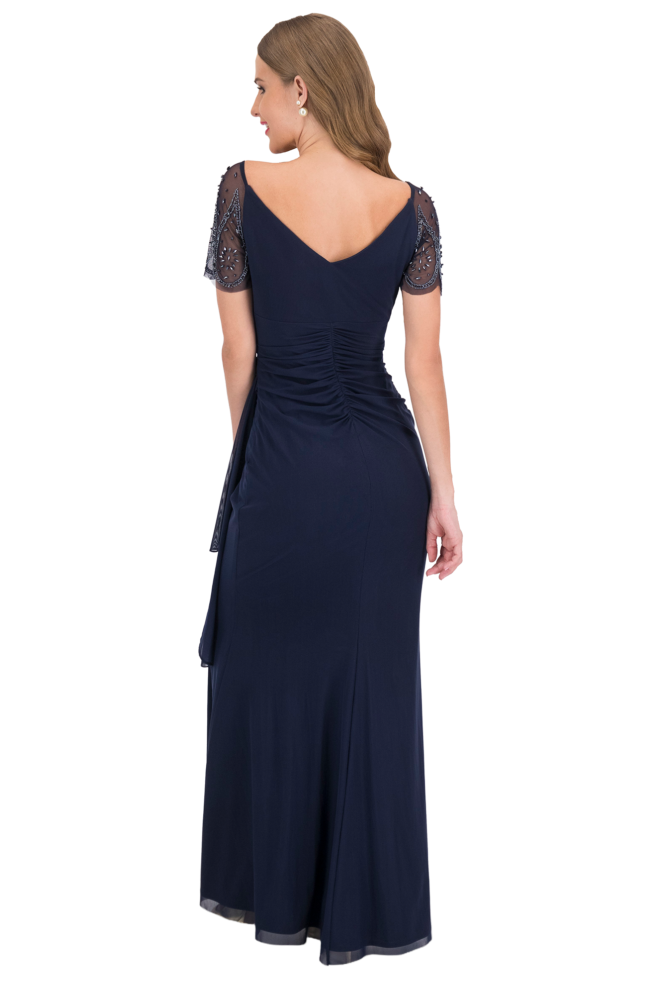 Back view of a woman in a navy evening gown with sheer, beaded sleeves and a ruched back detail.