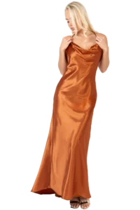 Blonde woman in a copper-orange satin evening gown, looking down and adjusting the dress straps.