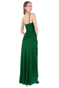 Model shown from behind in a floor-length emerald-green dress with thin straps, wearing long dangling earrings and looking over her shoulder.