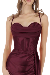 Woman wearing a burgundy satin evening gown with thin straps and a structured, corset-style bodice at the waist, shown from the shoulders to hips.