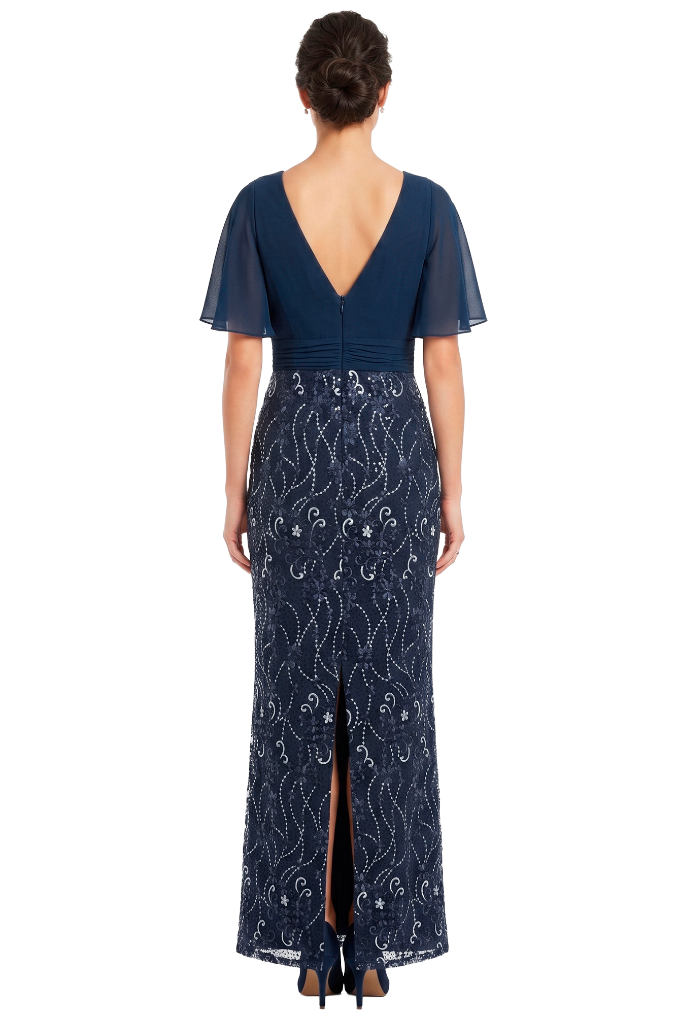 Back view of a woman in a navy evening gown with a V-shaped back, sheer flutter sleeves, and a lace-patterned skirt with a back slit