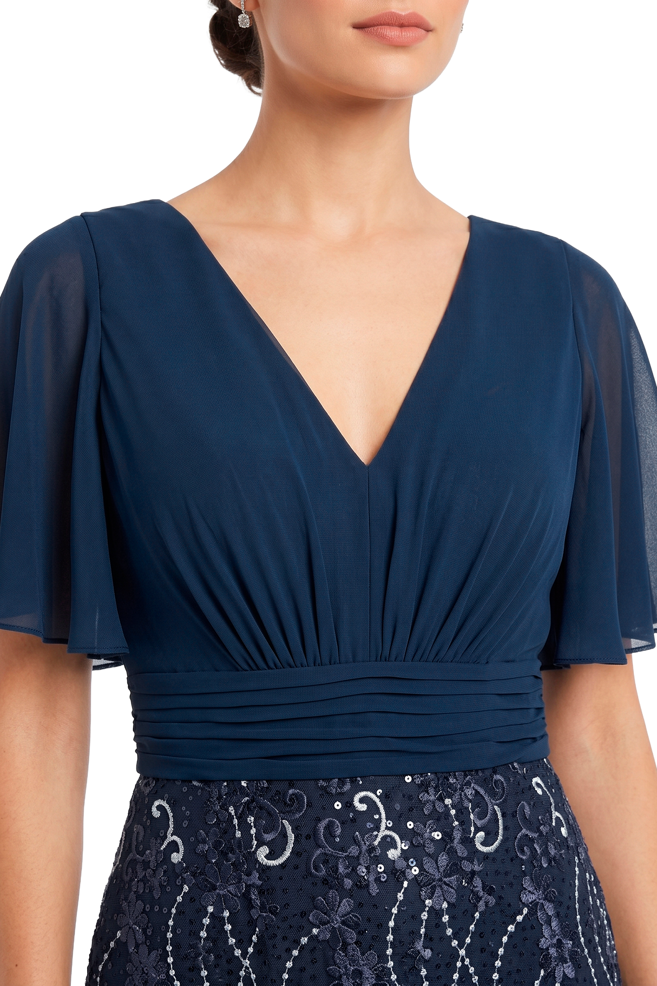 Woman wearing navy V-neck dress with sheer short sleeves and ruched waist.