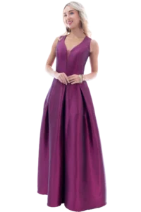 Full-length image of a woman in a magenta gown, standing with hands loosely clasped and smiling at the camera.