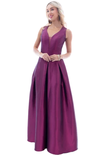 Full-length image of a woman in a magenta gown, standing with hands loosely clasped and smiling at the camera.