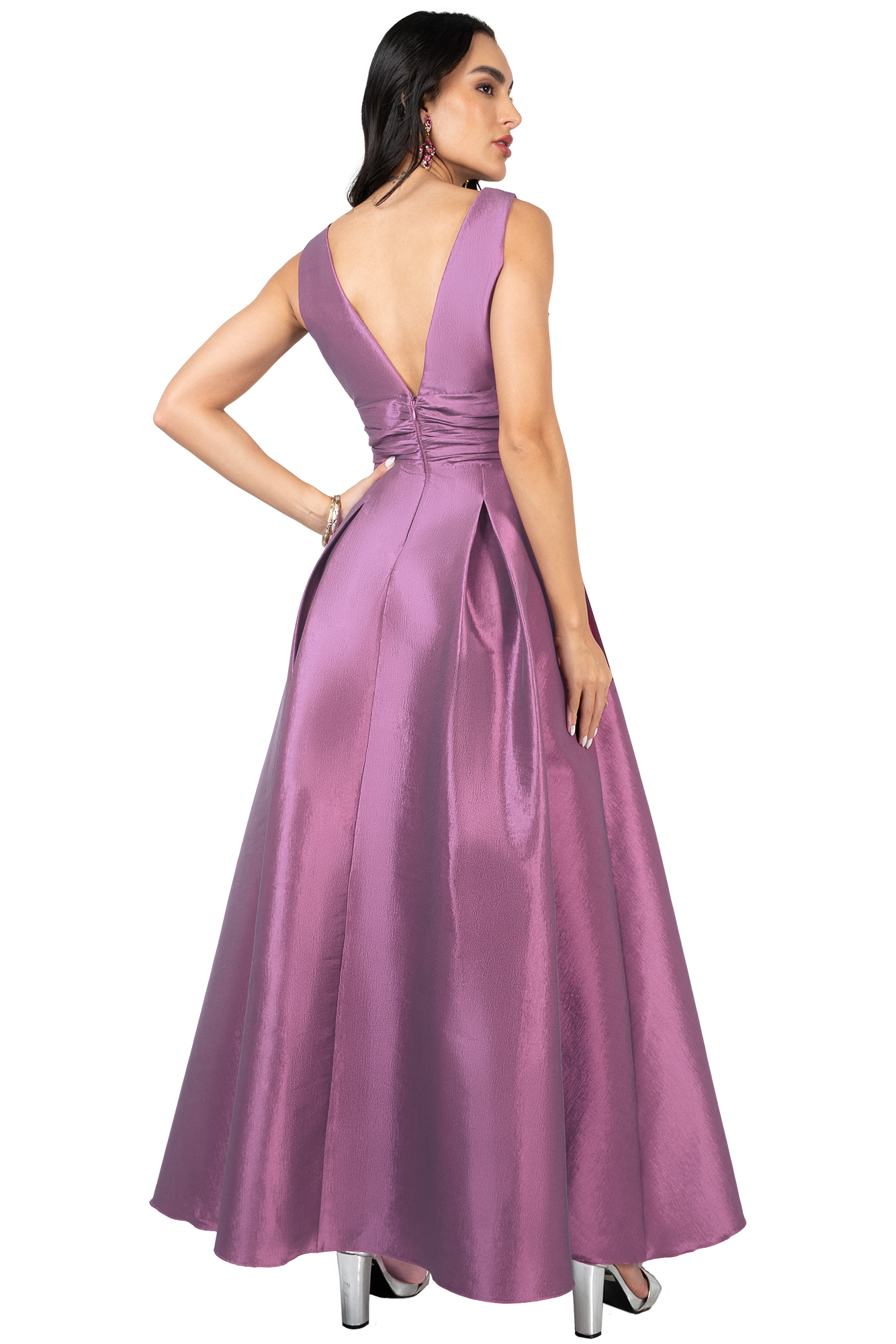 Back view of a woman in a lavender satin evening gown with a ruched waist and full skirt, wearing pink earrings and silver heels