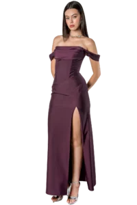 Woman in an off-shoulder burgundy satin gown with a thigh-high slit, silver heels, and a statement necklace posing confidently.