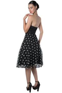 Woman in a black strapless polka-dot dress, shown from the back/side with heels, posing.