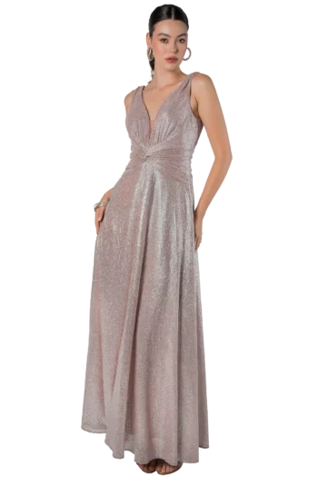 Woman wearing a sparkly blush-pink evening gown, standing with one hand at her side and bare feet visible beneath the hem
