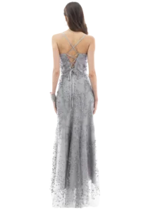 Back view of a woman in a silver-gray embellished gown with a crisscross lace-up back and flowing skirt.