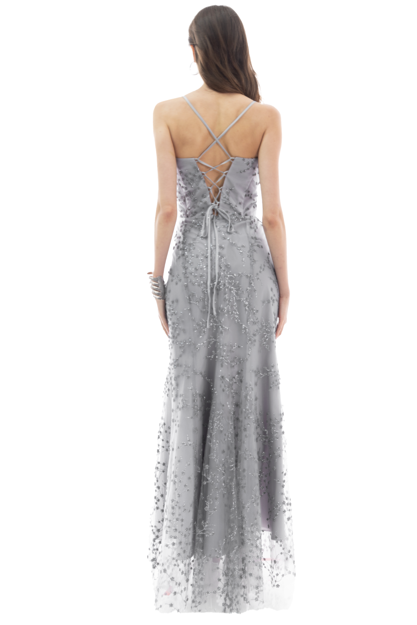 Back view of a woman in a silver-gray embellished gown with a crisscross lace-up back and flowing skirt.