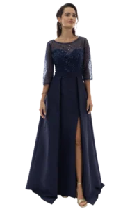 Woman in a navy sequined evening gown with sheer sleeves, standing with a slit showing her legs and sandals.