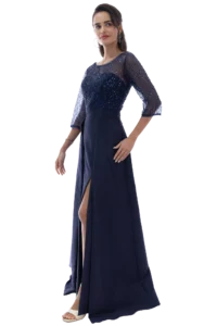 Woman wearing a navy sequin top with sheer sleeves and a matching high-waisted skirt with a front slit, posing gracefully.