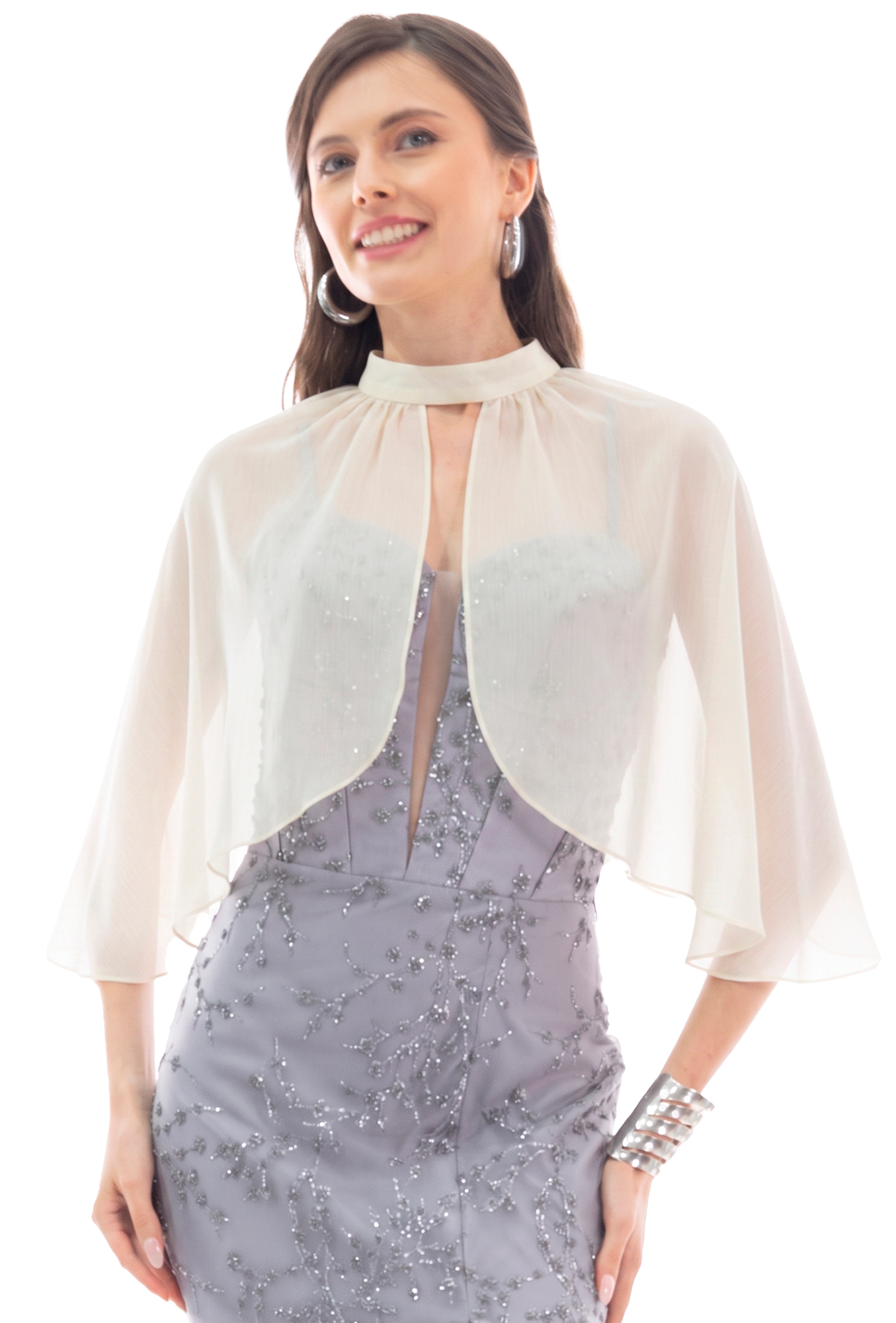 Woman in a lavender beaded evening gown with a sheer white cape, smiling at the camera, wearing large silver hoop earrings.