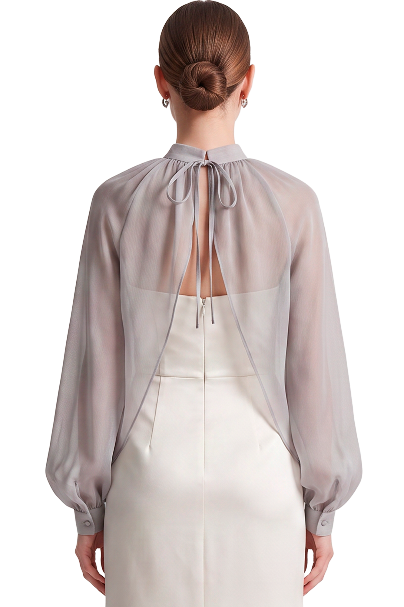 Back view of a person wearing a sheer gray blouse with a tied bow at the neck over a pale cream dress