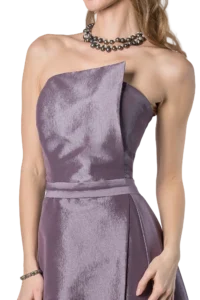 Woman in a lavender satin strapless gown wearing a layered pearl necklace and bracelet, featuring a textured bodice and off-shoulder neckline.
