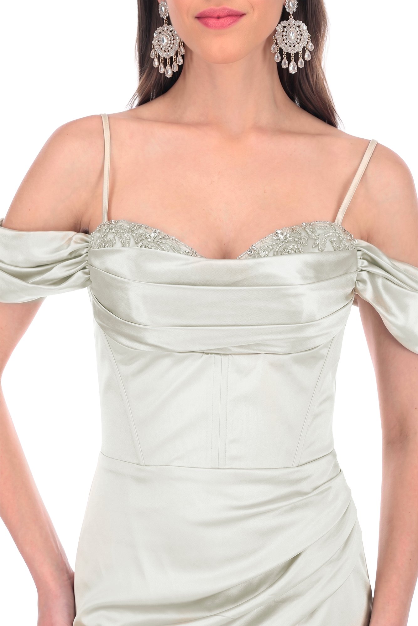 Close-up of a woman in a silver off-shoulder gown with beaded bodice and ornate chandelier earrings.