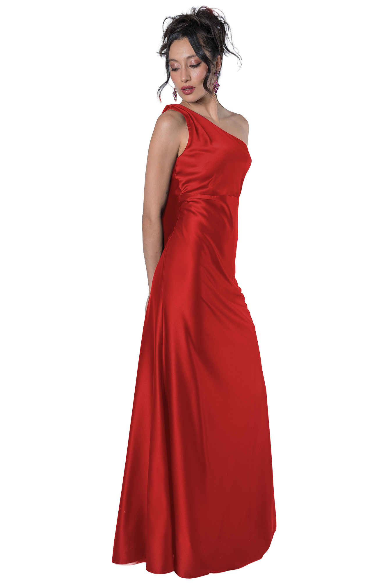 Woman in a red, one-shoulder satin gown posing gracefully, looking downward with pink earrings and styled hair against a black background.