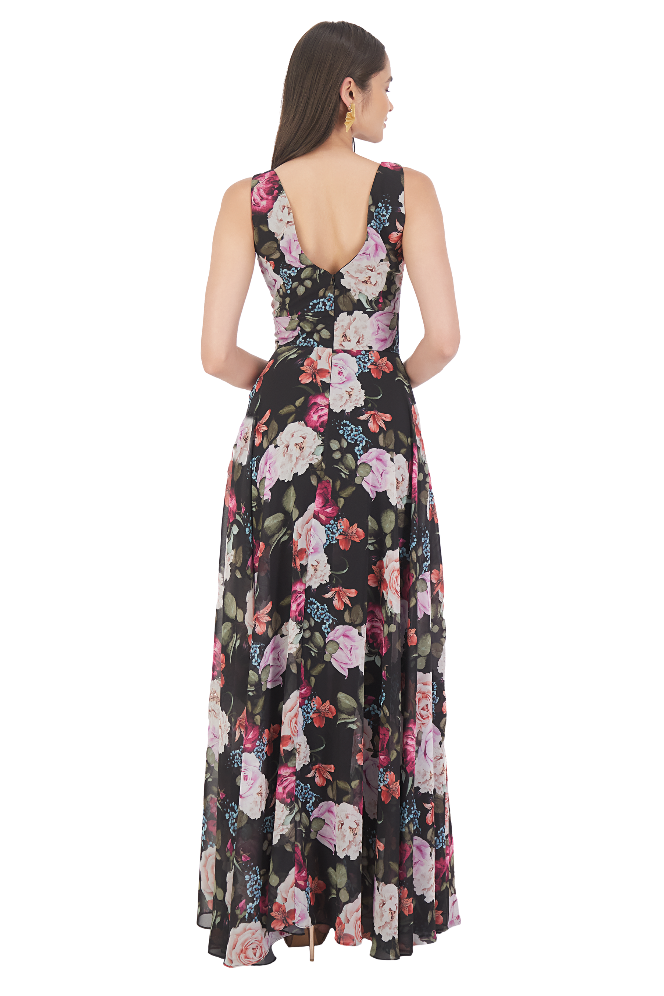 Modelo luciendo un jumpsuit con sobre falda en chiffon estampado floral sobre fondo negro, con escote en V, talle ajustado y pantalón recto.