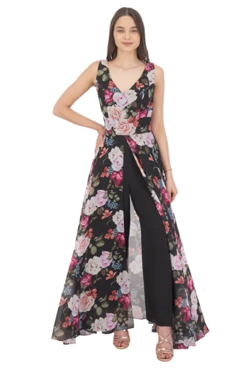 Modelo luciendo un jumpsuit con sobre falda en chiffon estampado floral sobre fondo negro, con escote en V, talle ajustado y pantalón recto.